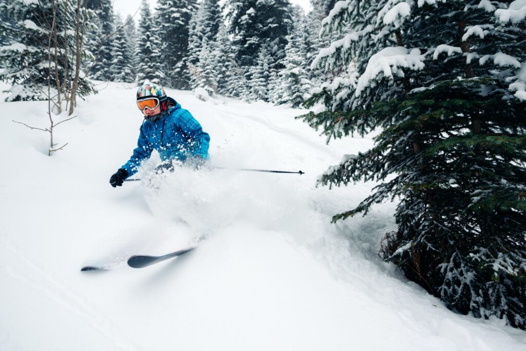 girl with special ski equipment is riding and jumping very fast in the mountain forest