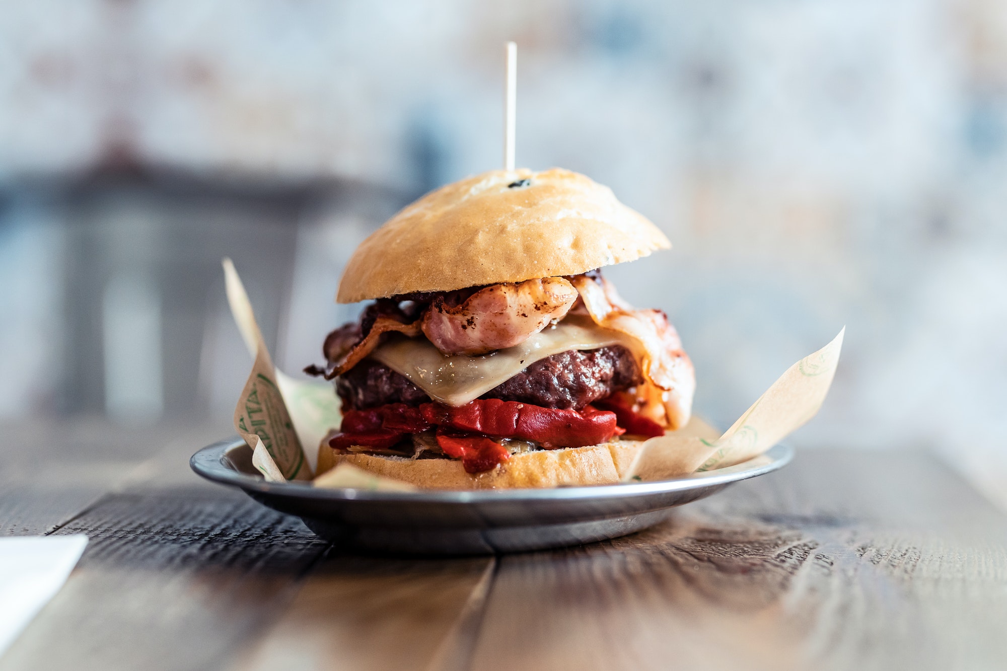 Delicious fresh homemade big burguer on a rustic wooden table in the restaurant.